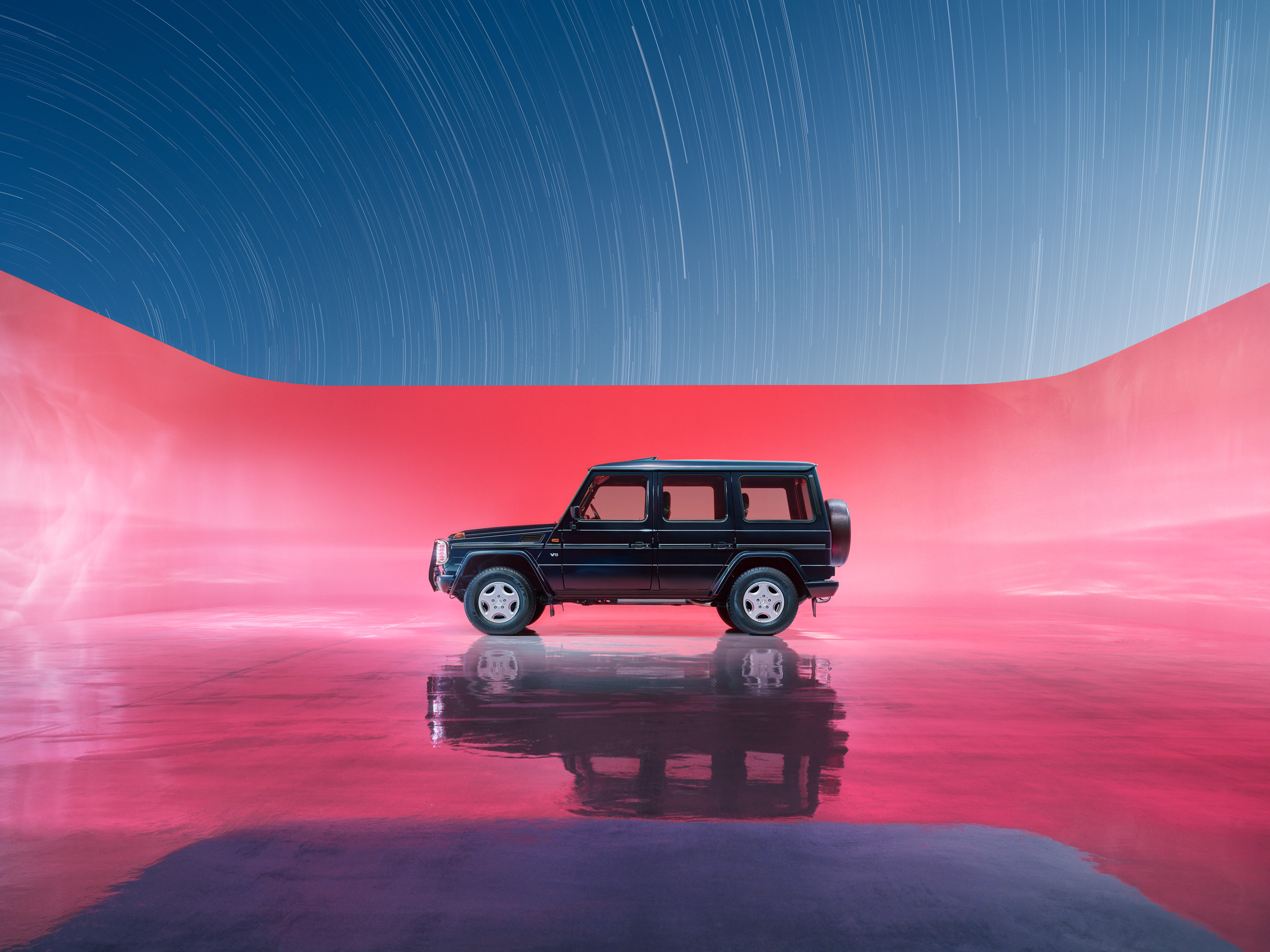 A black SUV is parked on a glossy surface with a pink-lit background and a sky full of star trails, evoking a futuristic scene reminiscent of drone light art.