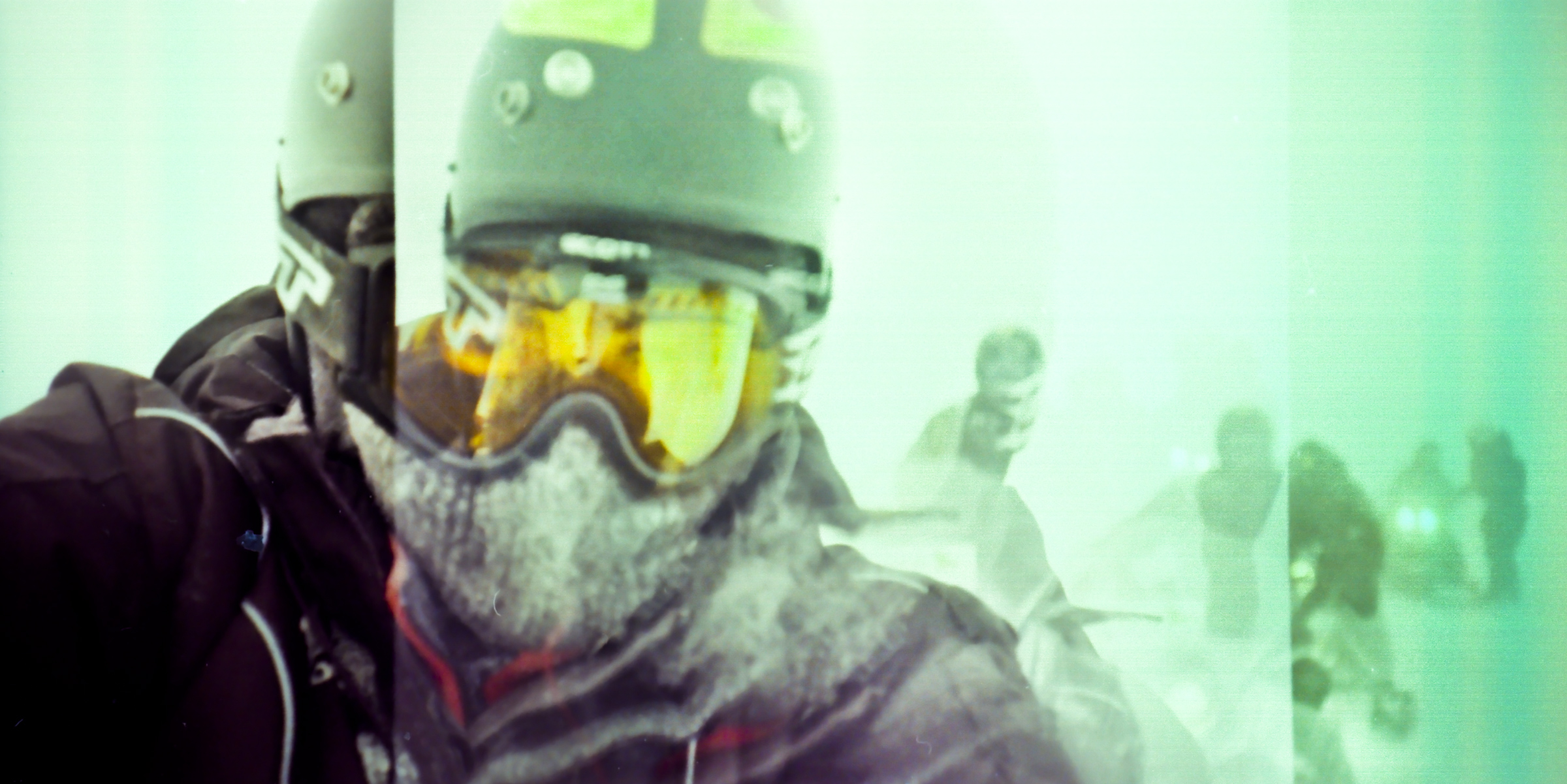Close-up of a person in a helmet and goggles, face frosted, riding in snowy, wintry conditions—a scene captured with a fine artist’s eye for detail and atmosphere.