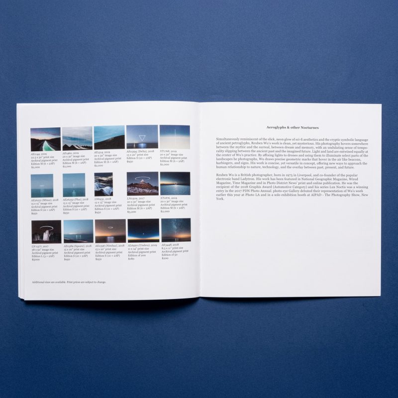 An open book on a blue surface, featuring nighttime landscape photography with captions on the left and text on the right page.