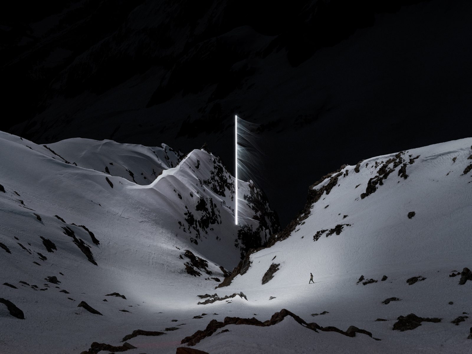 A lone person walks in snowy mountains at night, with a glowing vertical light in the distance, capturing the mystery of nighttime landscape photography.