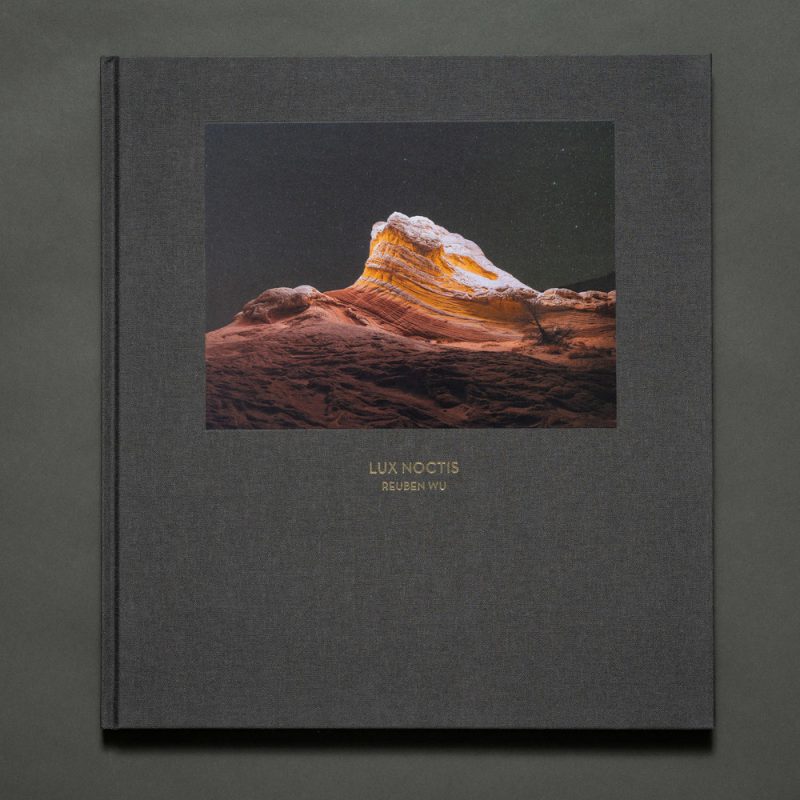 Photo book titled Lux Noctis by fine artist Reuben Wu, featuring a stunning nighttime landscape photography cover illuminated by drone light painting.