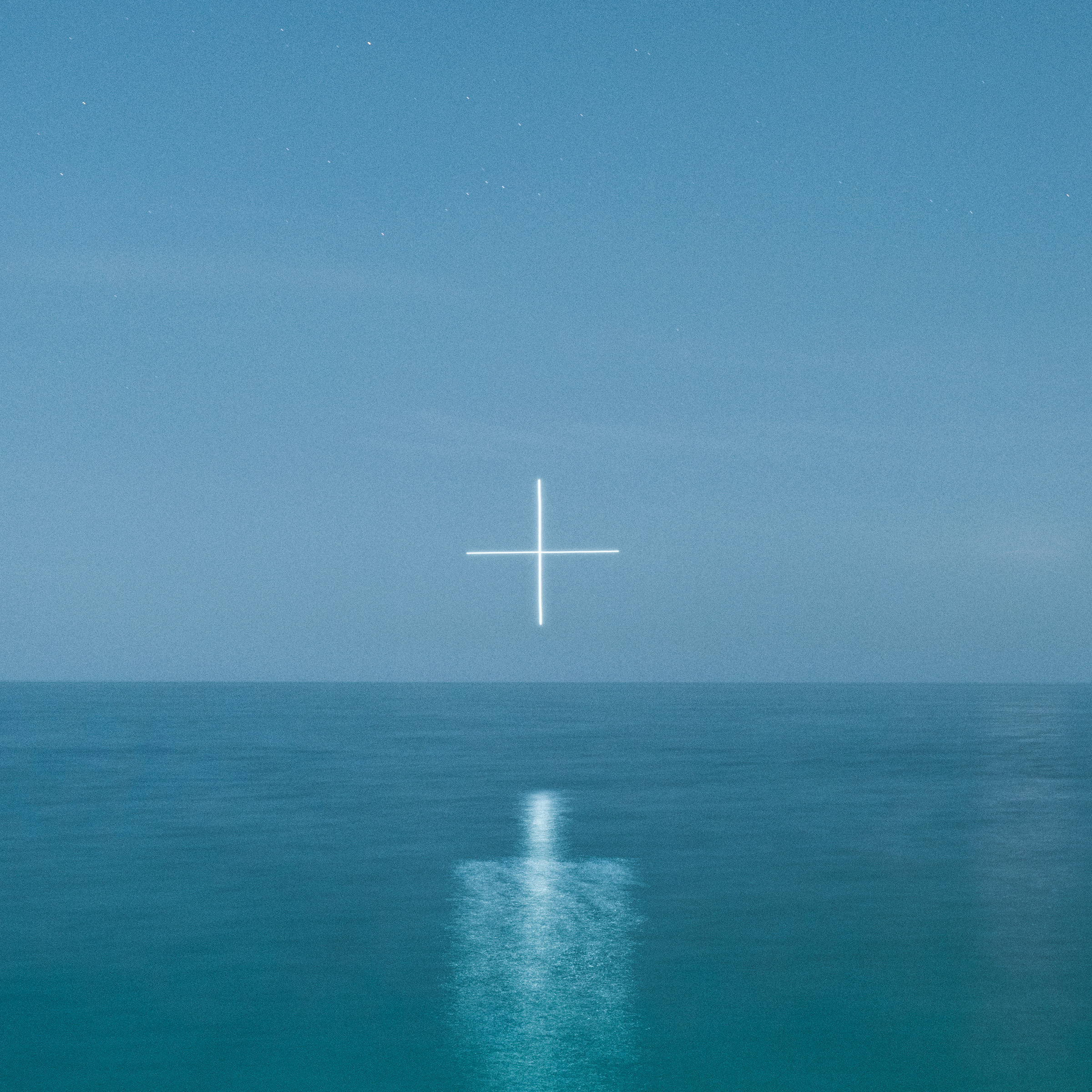A glowing white plus sign floats above a calm blue ocean under a clear sky at dusk, creating a futuristic scene reminiscent of drone light art.
