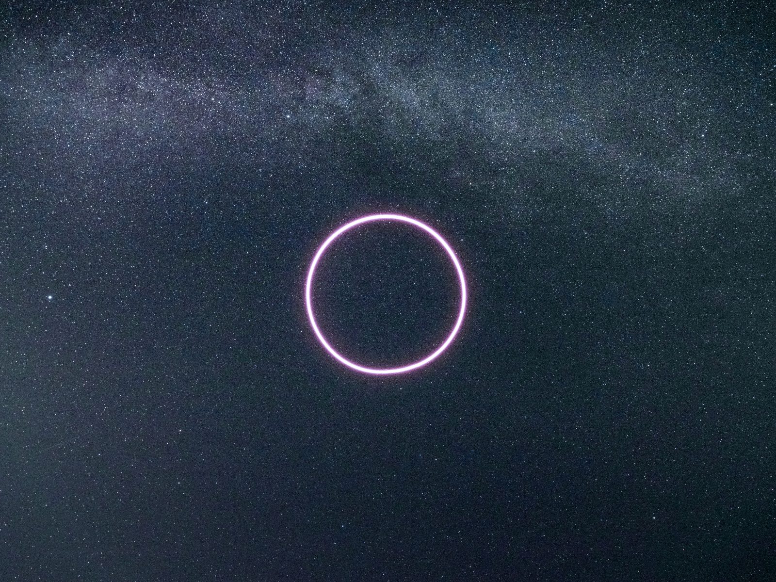 A glowing pink neon circle, reminiscent of futuristic drone light art, hovers against a starry night sky with a faint Milky Way background.
