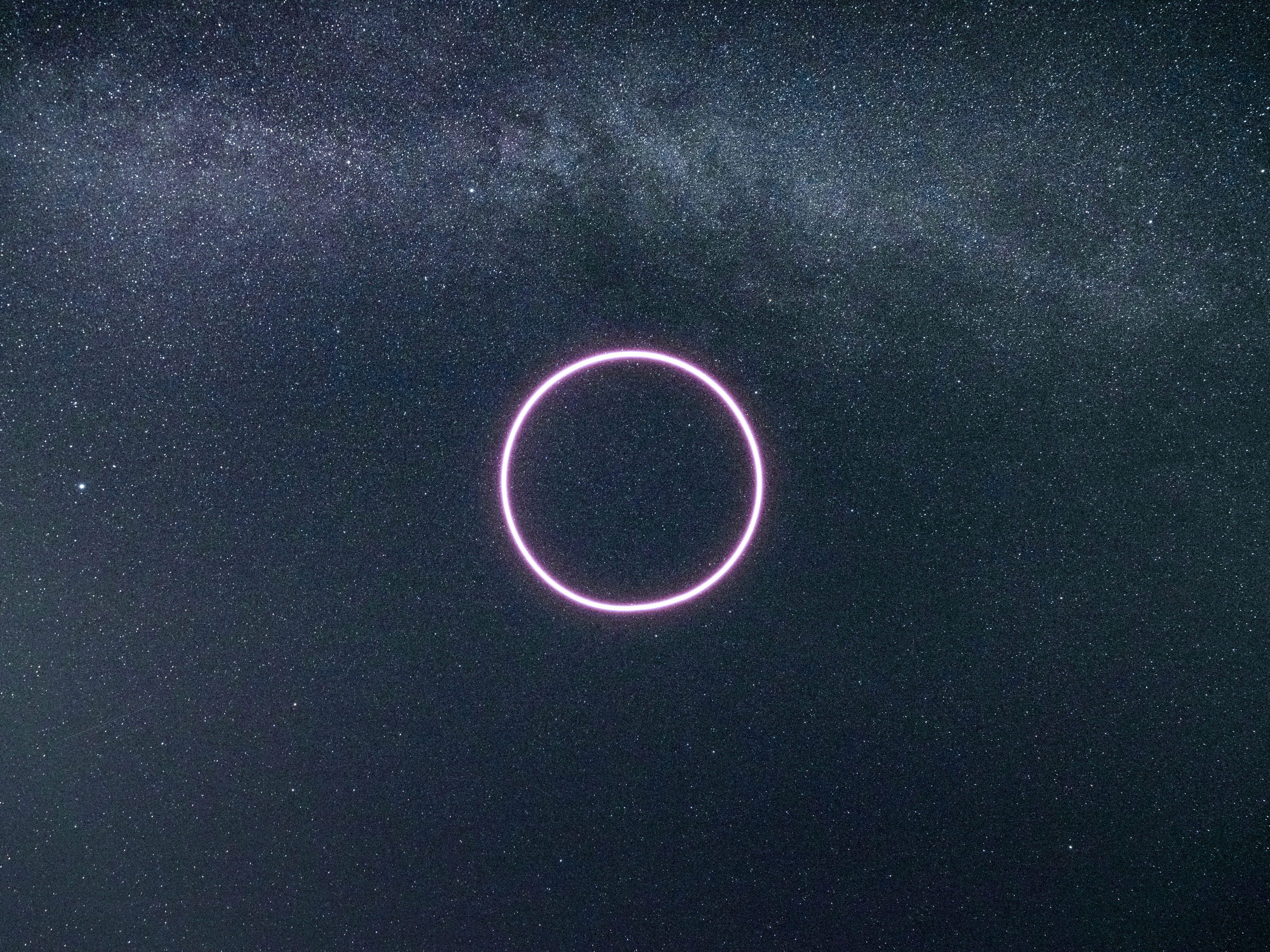 A glowing pink neon circle, reminiscent of futuristic drone light art, hovers against a starry night sky with a faint Milky Way background.